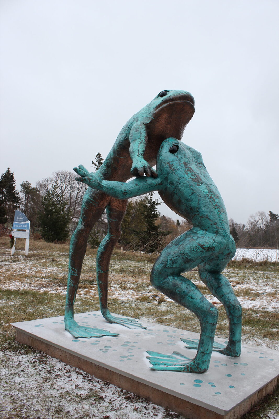 Two frog sculptures with one leaping over the other